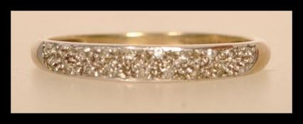 A hallmarked 9ct gold and diamond half eternity ring having half decoration with illusion set
