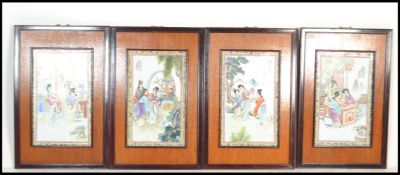 A set of four 20th century Chinese hardwood framed ceramic panels decorated with typical domestic
