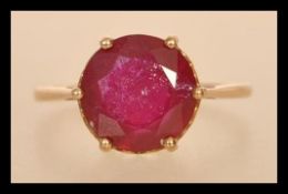 A 20th century stamped 375 gold yellow metal ring with a brilliant cut ruby in a prong and heart