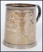 An early 20th century silver hallmarked tankard raised on a stepped circular base with shaped