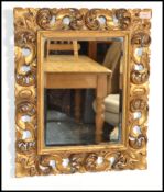 A vintage Florentine gilt wood framed wall mirror with shell and acanthus carved decoration, with