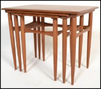 A nest of three Danish retro teak wood side tables, the graduating three tables raised on shaped