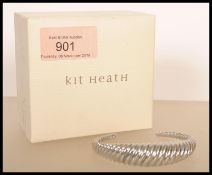 A silver bangle by Kit Heath of twisted form, stamped 925. Weight 39g.