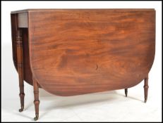 A good 19th century George III solid mahogany drop leaf / gateleg dining table being raised on