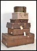 A stack of vintage suitcases to include canvas and wooden bound trunk, leather style suitcases,
