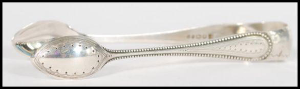 A pair of 19th century Victorian silver hallmarked sugar tongs having a beaded and engraved design