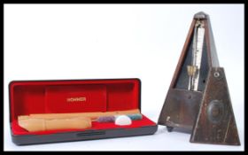 A vintage early 20th Century German ' System Maelzel ' metronome together with a Hohner Baroque