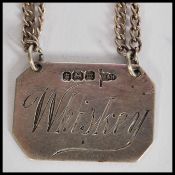 An early 20th century silver hallmarked miniature whiskey toddy decanter label of octagonal form