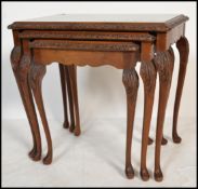 A vintage 20th century carved walnut nest of three side occasional tables raised on cabriole legs