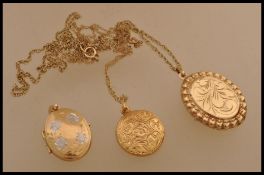 A group of three 9ct gold locket pendants two being set on 9ct gold necklace chains. Total weight