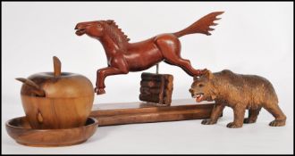 A collection of treen items to include a Black Forest bear, a horse jumping a fence and a lidded