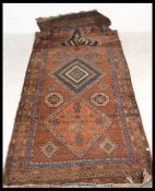 A vintage 20th Century floor rug / mat / runner on red ground, central panel with geometric