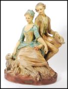 A large oversized 1920's chalkware figural group statue of a Georgian lady and gentleman sitting