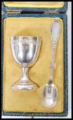 An early 20th century French silver egg cup and spoon bearing silver purity marks complete in