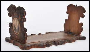 A 19th century Victorian carved wooden Blackforest book trough / slide having scrolled decoration