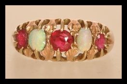 A 9ct gold opal and pink stone ring having alternating faceted pink stones and opal cabochons.