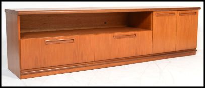 A 1970's G-Plan teak wood sideboard base raised on plinth with a series of cupboards having blind