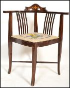 An Edwardian mahogany and marquetry inlaid corner chair / armchair being raised on shaped squared