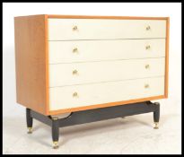 A mid century G-Plan natural oak and white painted chest of drawers. Raised on an ebonised base with