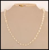A cultured pearl necklace with a lobster clasp along with a small simulation pearl bracelet.