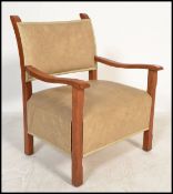 A 20th century Art Deco open framed armchair having shaped elbow rests in oak with overstuffed