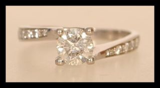 A 14ct white gold and diamond ring having a central brilliant cut diamond of approx 65pts and