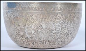 A 19th century Indian silver prayer bowl having embossed peacock and birds of paradise decoration