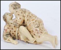 A pair of Japanese Karma Sutra erotic ivorine figures of a couple along with a pair of reclining