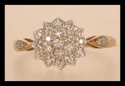 A hallmarked 9ct gold and diamond cluster ring having accent diamonds to shoulders. Size Q. Weight