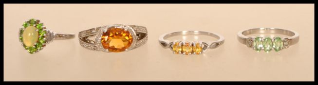 A selection of silver rings to include a stamped 925 split band ring set with an oval cut orange