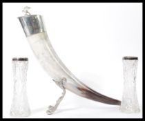 A large ox horn - claret jug having silver plated collar and lid with shaped white metal stand