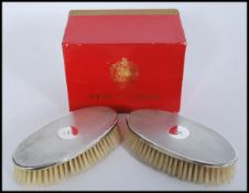 A cased pair of silver hallmarked brushes retailed by Kent of London complete in original box.