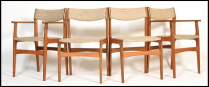 A set of 4 mid century teak wood dining chairs being raised on shaped legs with original wool