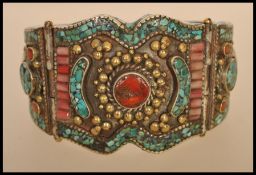 A Chinese / Himalayan silver white metal bangle bracelet set with coral cabochons, turquoise and