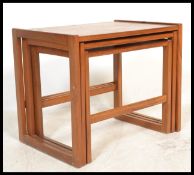 A 1970's teak wood Danish manner nest of tables. Each raised on shaped legs with returns to the
