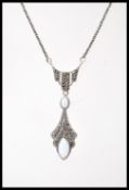 A silver Art Deco style pendant necklace set with two opals and marcasite accent stones. Weight 8.