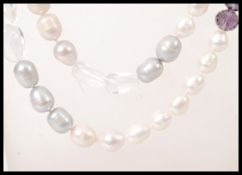A long ladies fresh water pearl necklace having faceted aqua marine and amethyst spacers. Measures