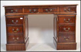 An antique Georgian style mahogany twin pedestal office desk having pedestals, each with banks of