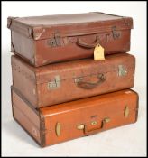 A stack of vintage suitcases / trunks to include a good leather Samsonite example and 2 early 20th