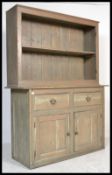 An early 20th century Welsh dresser being raised on a plinth base with a series of cupboards and