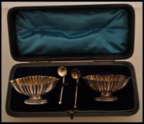 A pair of 19th Century hallmarked silver salt cellars with oval bases and fluted decoration, with
