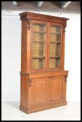 A Victorian oak library bookcase cupboard cabinet raised on a plinth base having twin door