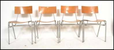 A set of four vintage retro 20th Century village hall tubular framed stacking chairs, the stacking