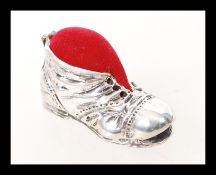 A sterling silver pincushion in the form of a boot. Weight 15.9g.
