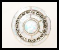 A silver Art Deco style ring having concentric circular opal panels to the head with inset