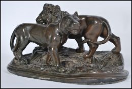 A vintage 20th century bronze effect bronzed figurine group of a lion and lioness raised on