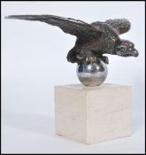A vintage early 20th century silver plated bronze car mascot in the form of an eagle raised on