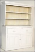 A Victorian painted pine country dresser being raised on a plinth base with twin cupboard doors