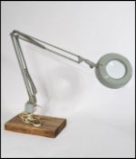 A vintage 20th Century industrial illuminated magnifying optic, raised on an standing anglepoise