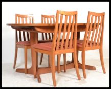 A late 20th century G-Plan teak wood dining table and chairs.  The extending table raised on